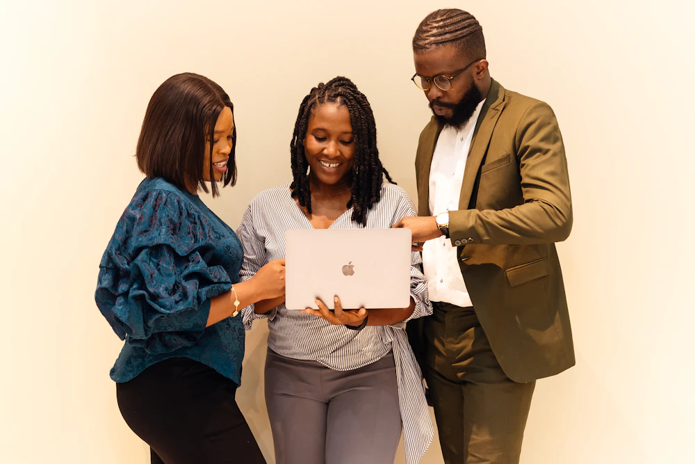 Three professionals reviewing a laptop together